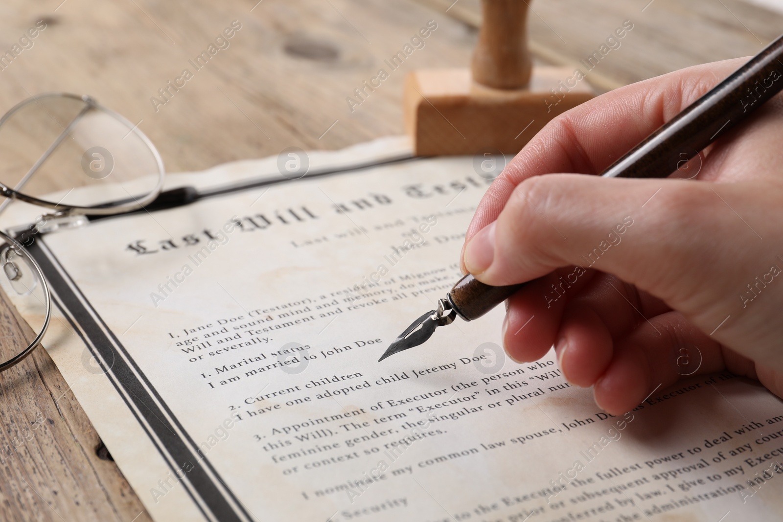 Photo of Woman signing Last Will and Testament at wooden table, closeup