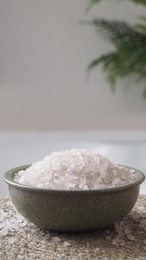 Photo of Bowl with bath salt on wicker mat indoors