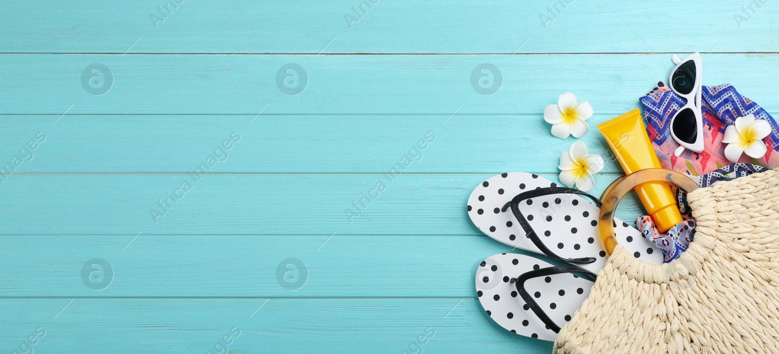 Image of Flat lay composition with beach accessories on light blue wooden background, space for text. Banner design