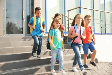 Cute little children with backpacks outdoors. Elementary school