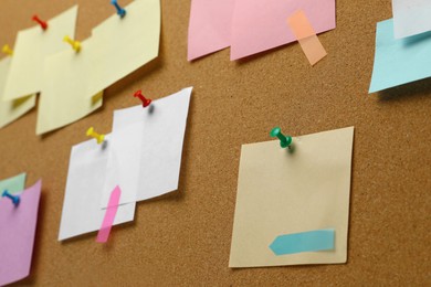 Photo of Colorful paper notes pinned to cork board, closeup