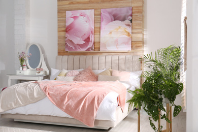 Photo of Stylish room interior with large comfortable bed and beautiful paintings