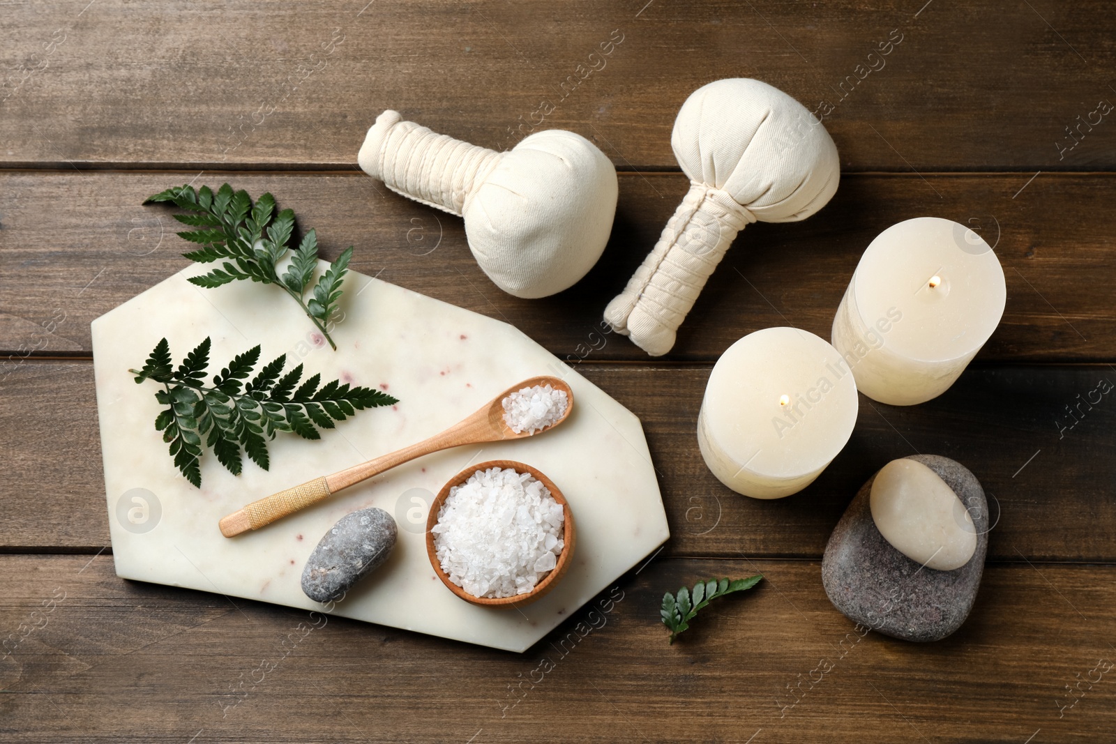 Photo of Flat lay composition with burning candles and herbal bags on wooden table