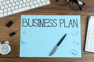 Photo of Flat lay composition of paper with words Business Plan on wooden table