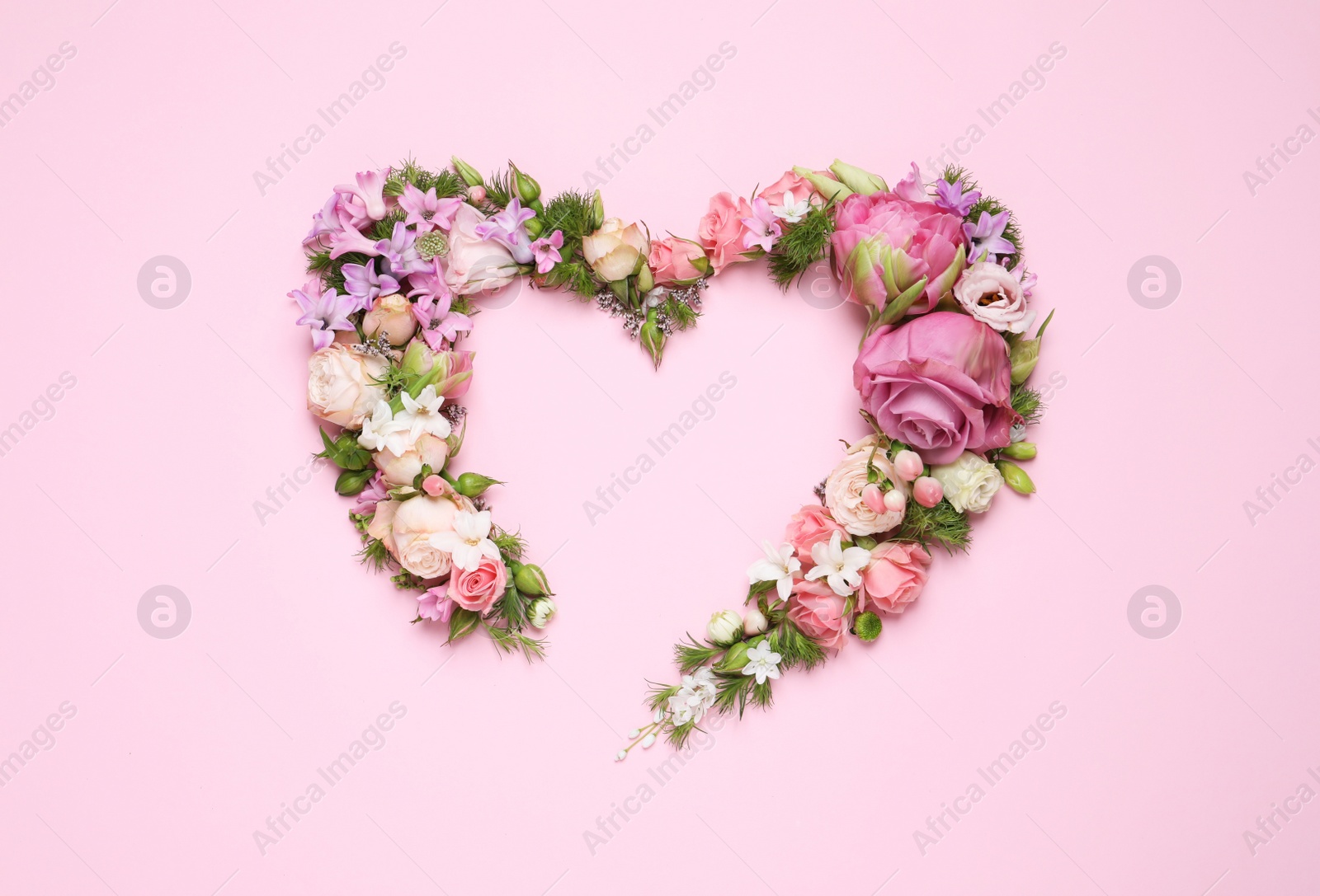 Photo of Beautiful heart made of different flowers on pink background, flat lay. Space for text