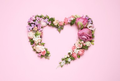 Beautiful heart made of different flowers on pink background, flat lay. Space for text