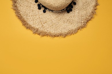 Straw hat on orange background, top view with space for text. Sun protection