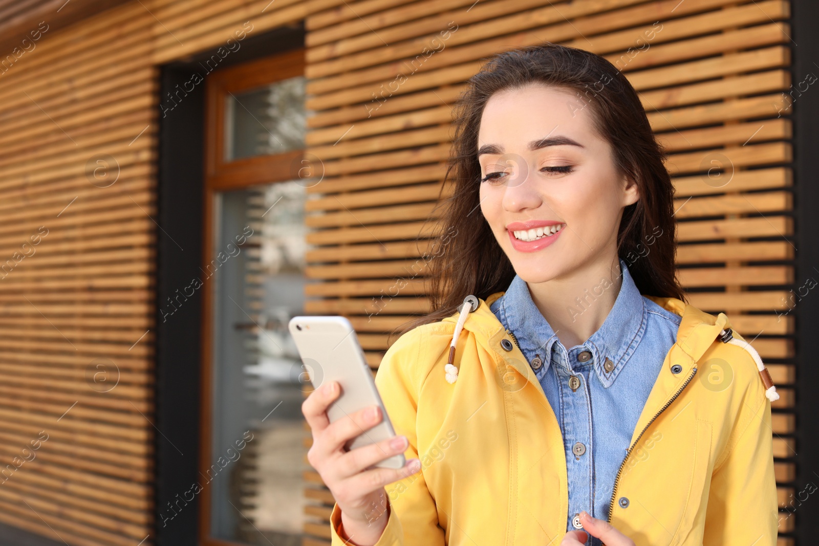 Photo of Beautiful young woman using phone outdoors