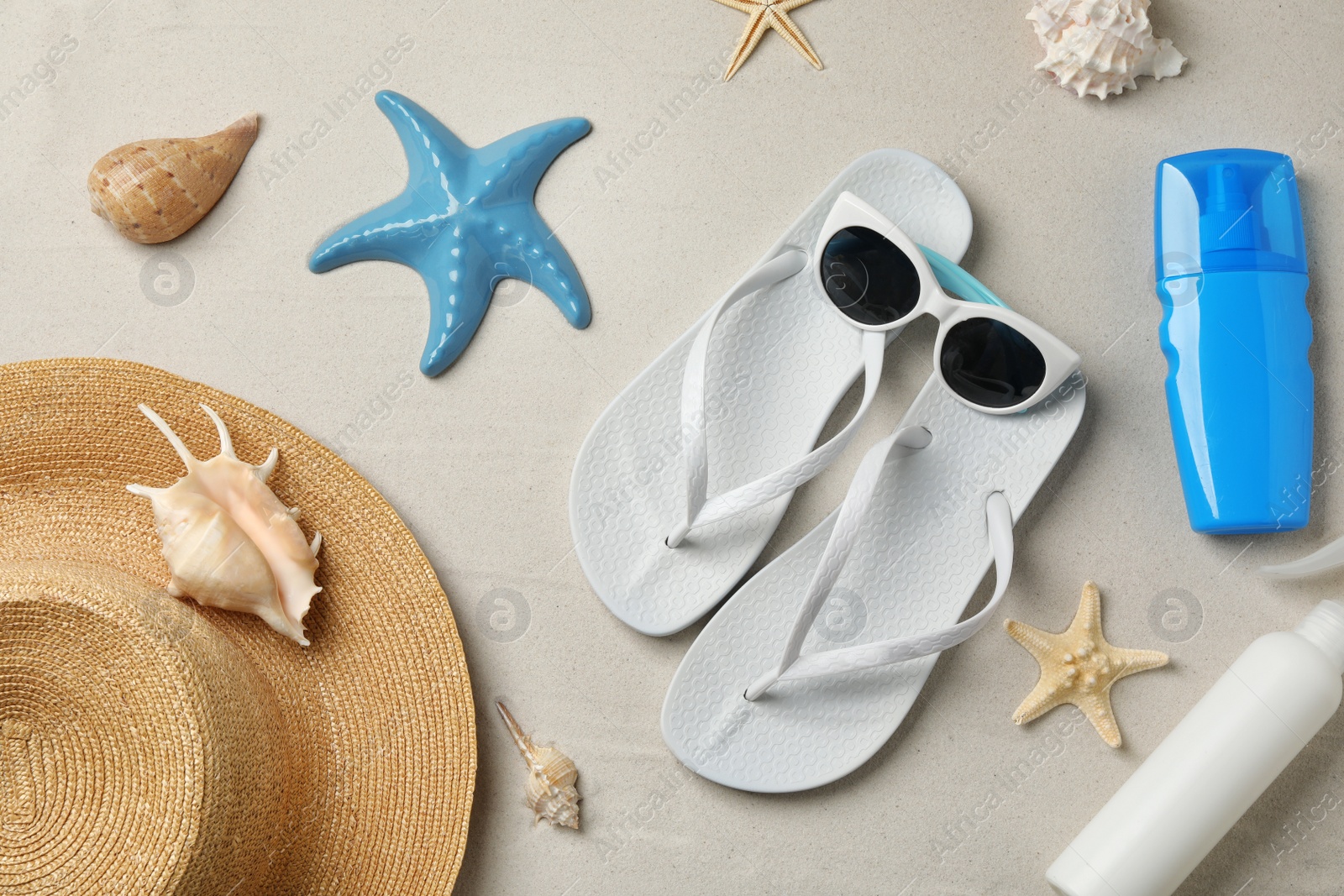 Photo of Flat lay composition with beach accessories on sand