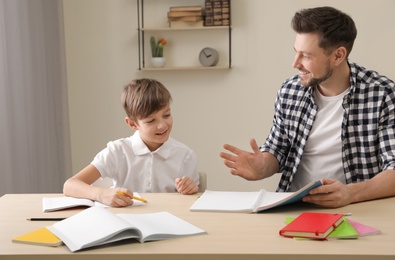 Photo of Dad helping his son with school assignment at home