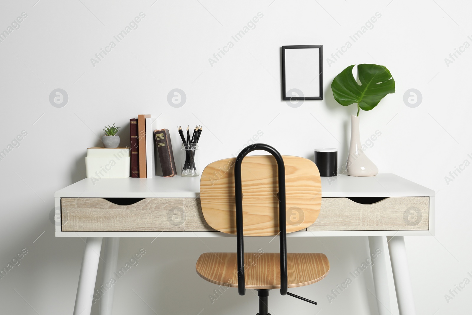 Photo of Comfortable workplace with white desk near wall