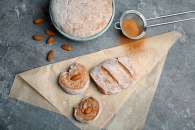 Flat lay composition with raw rye dough and almonds on grey background