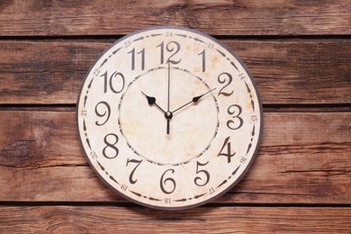 Photo of Stylish round clock on wooden table, top view. Interior element