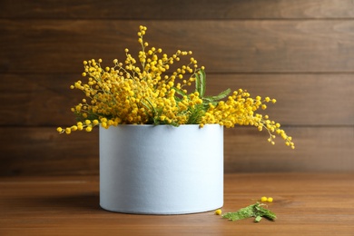 Photo of Bouquet of beautiful mimosa flowers on wooden table