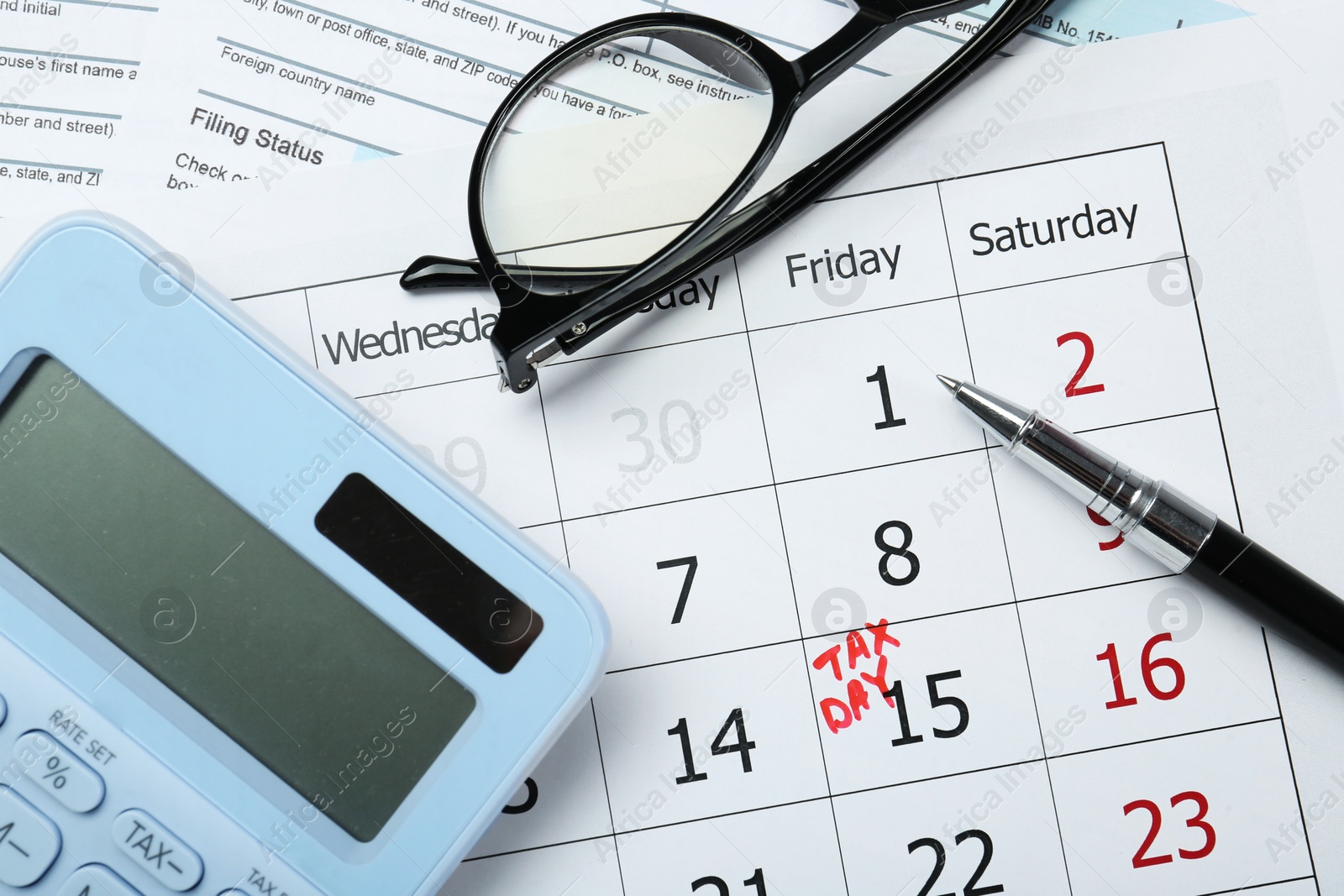 Photo of Tax day. Calendar with date reminder, pen, glasses, documents and calculator on table, flat lay