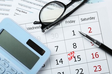 Tax day. Calendar with date reminder, pen, glasses, documents and calculator on table, flat lay