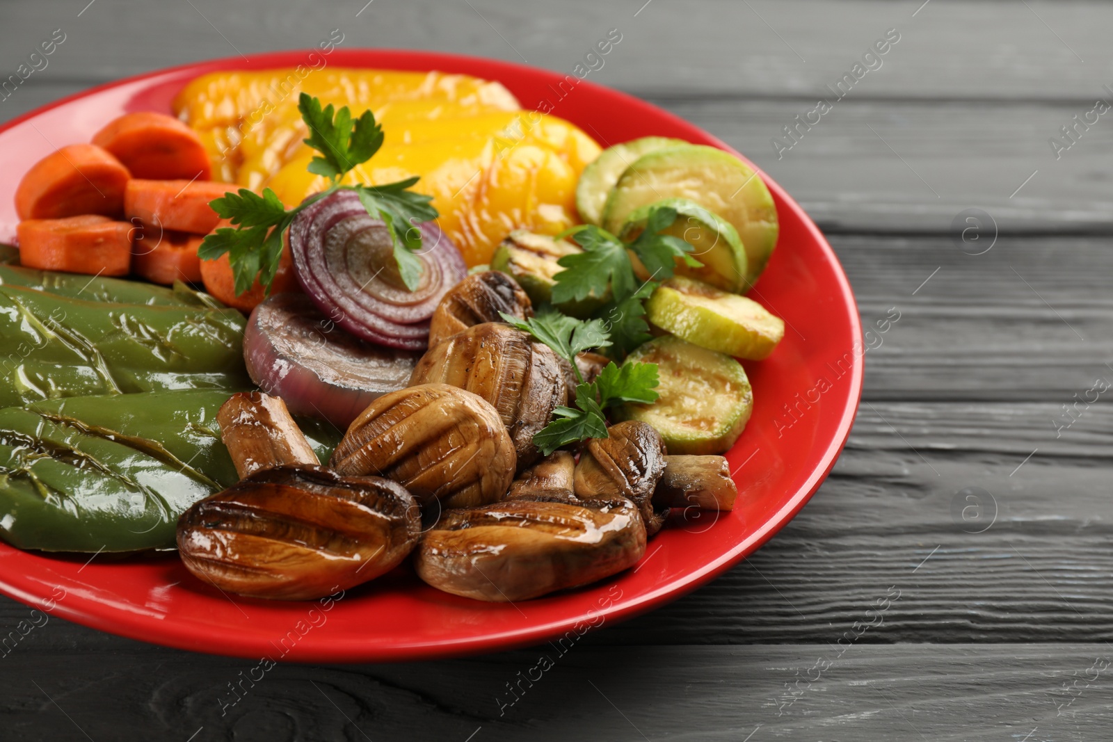 Photo of Delicious grilled vegetables on grey wooden table, closeup