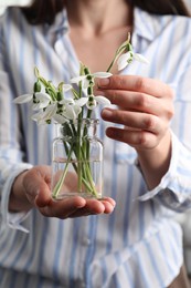 Woman holding glass jar with snowdrops, closeup