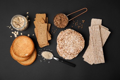 Photo of Rye crispbreads, rice cakes and rusks on black background, flat lay