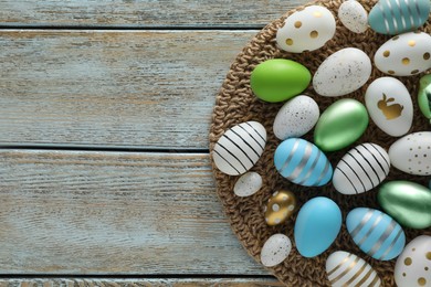 Photo of Many beautiful Easter eggs on wooden table, top view. Space for text