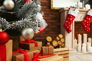 Decorated Christmas tree and gift boxes in festive room interior