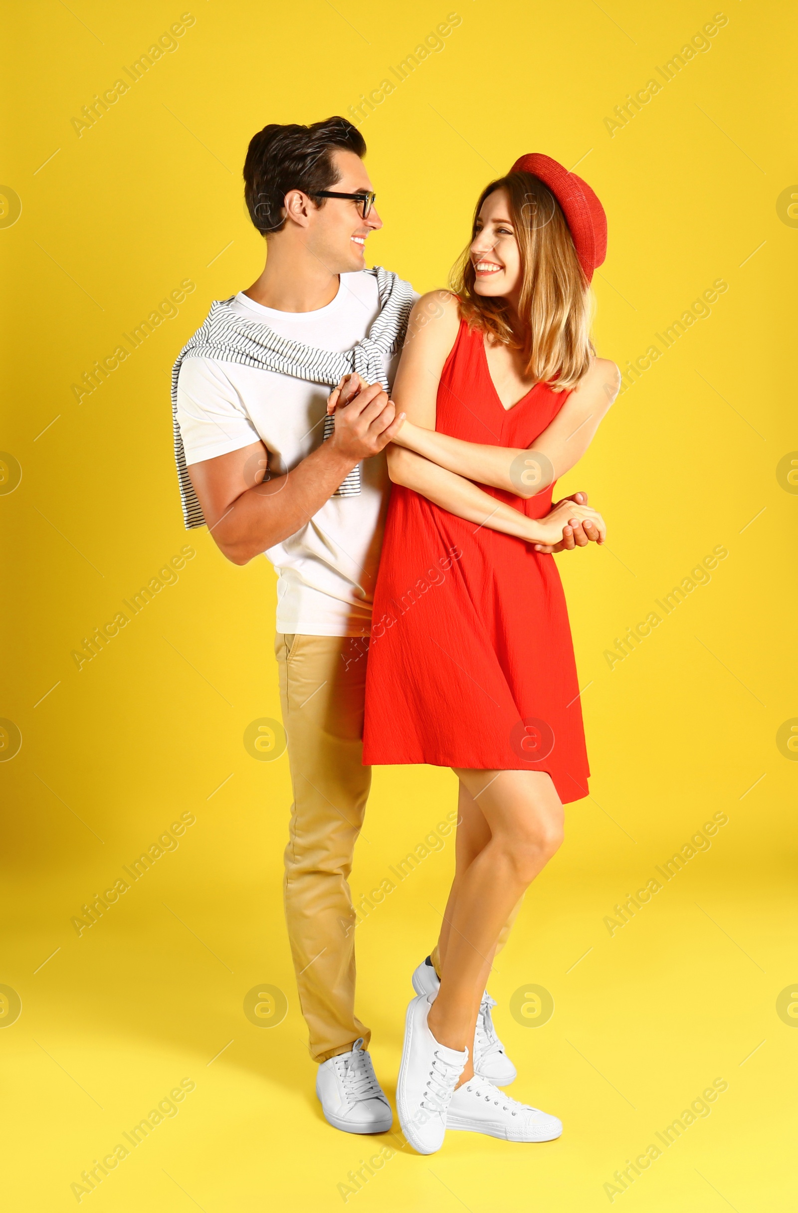 Photo of Beautiful young couple dancing on yellow background