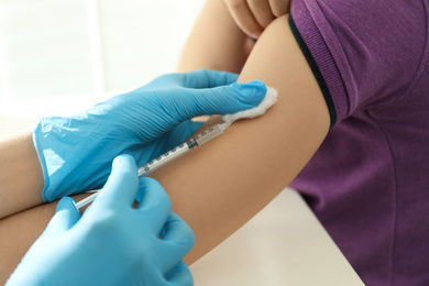 Photo of Doctor vaccinating little child in clinic, closeup