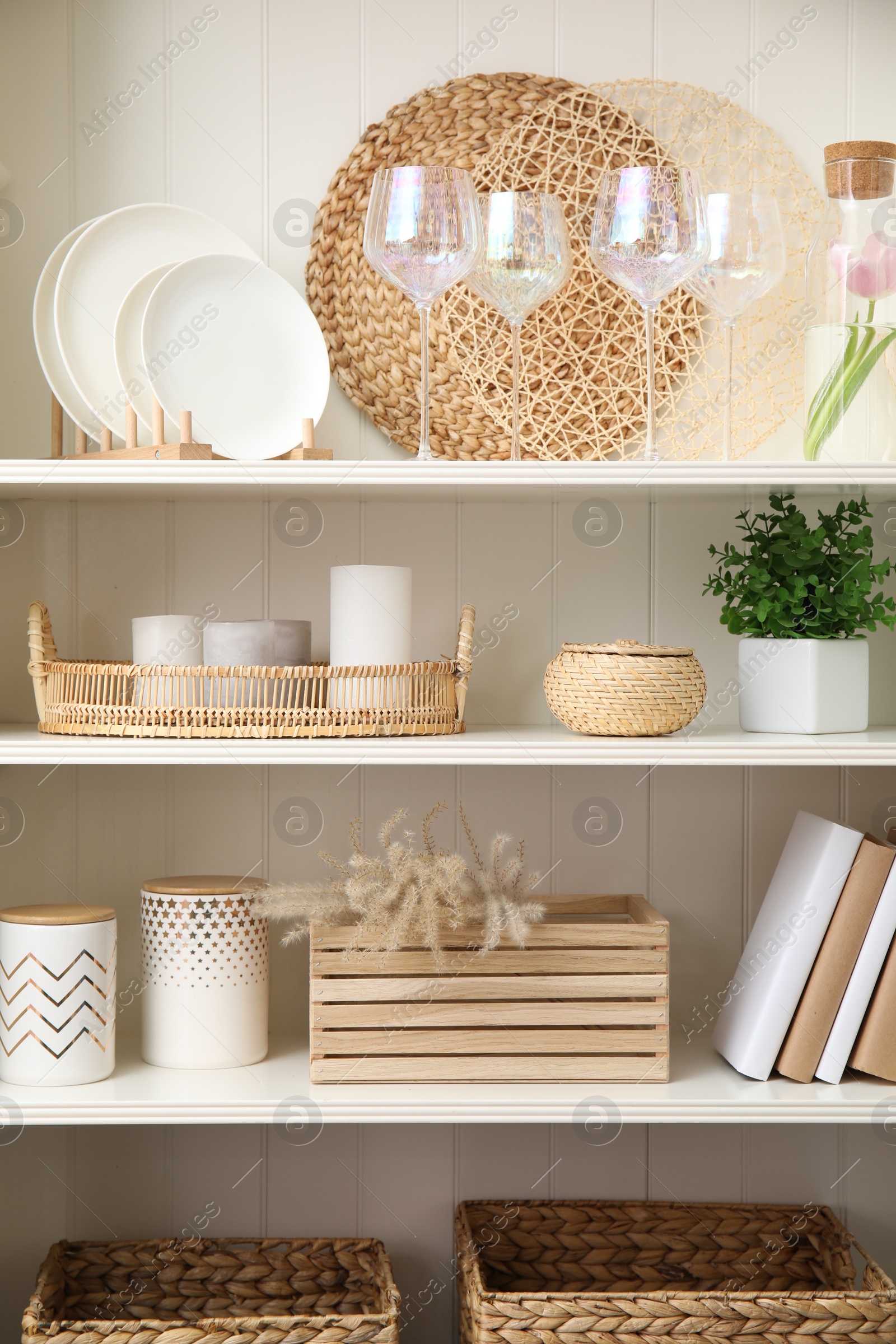 Photo of White shelving unit with dishware and different decorative stuff