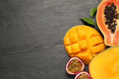 Photo of Fresh ripe papaya and other fruits on black table, flat lay. Space for text