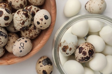 Photo of Unpeeled and peeled boiled quail eggs on white table, flat lay