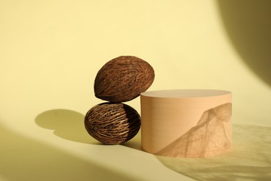 Photo of Presentation of product. Wooden podium and nutmegs on yellow background. Space for text