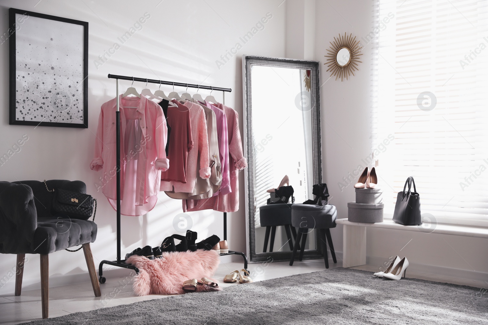 Photo of Dressing room interior with clothing rack and comfortable chair