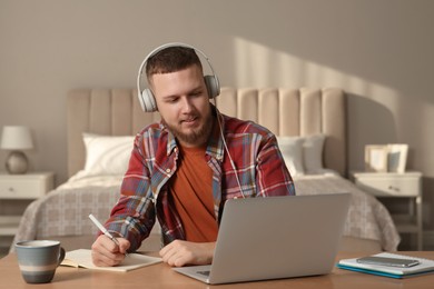 Photo of Online test. Man studying with laptop at home