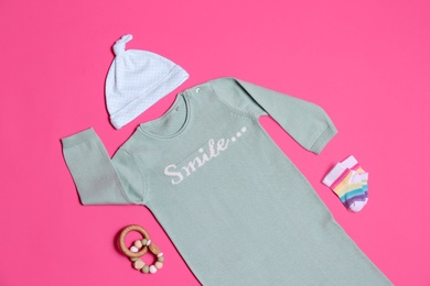 Photo of Flat lay composition with baby clothes and toy on pink background