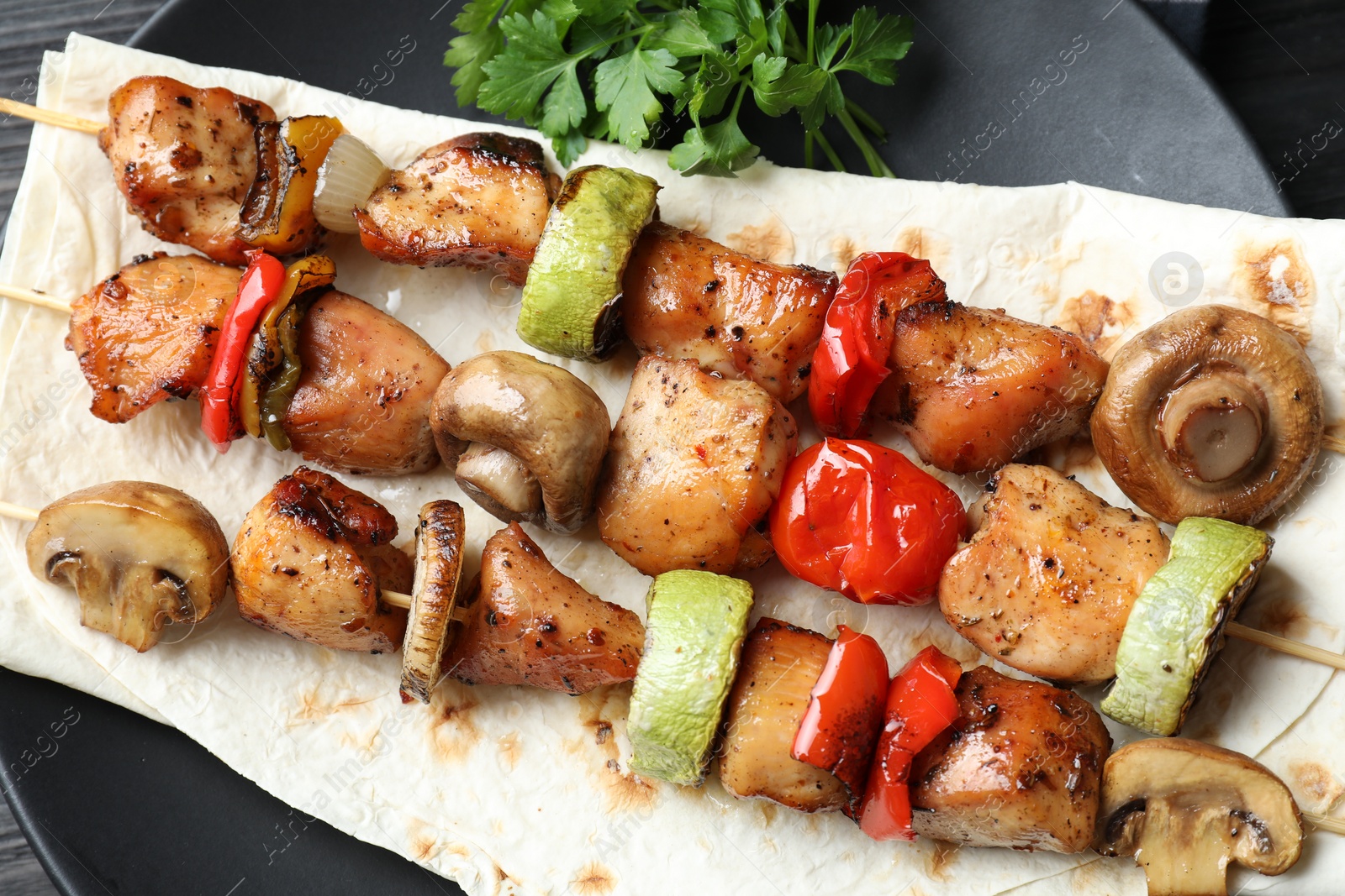 Photo of Delicious shish kebabs with vegetables on table, top view