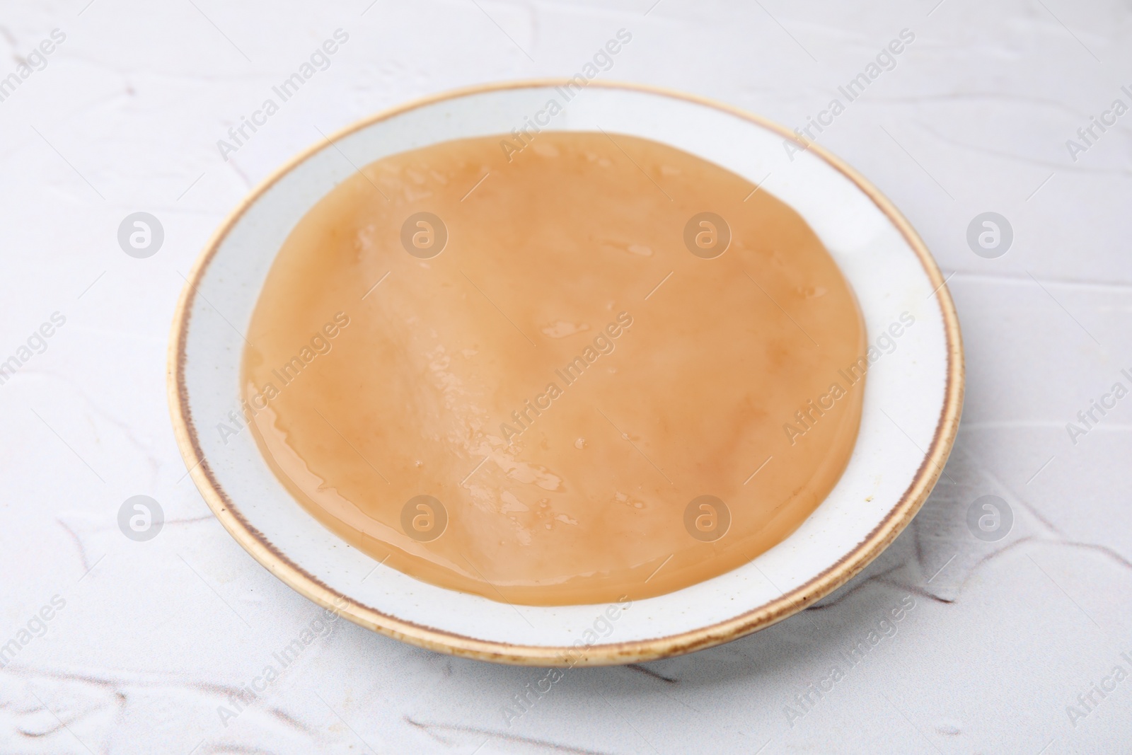 Photo of Making kombucha. Scoby fungus on white textured table