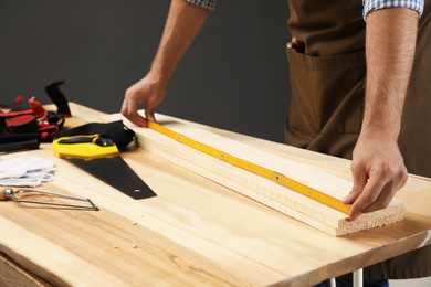 Photo of Carpenter working with timber at table, closeup