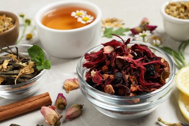 Photo of Different dry aromatic teas on light table, closeup