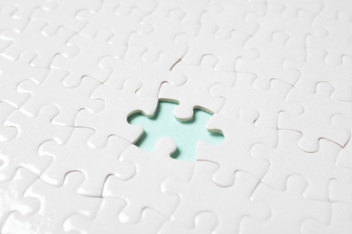 Photo of Blank white puzzle with missing piece on light blue background