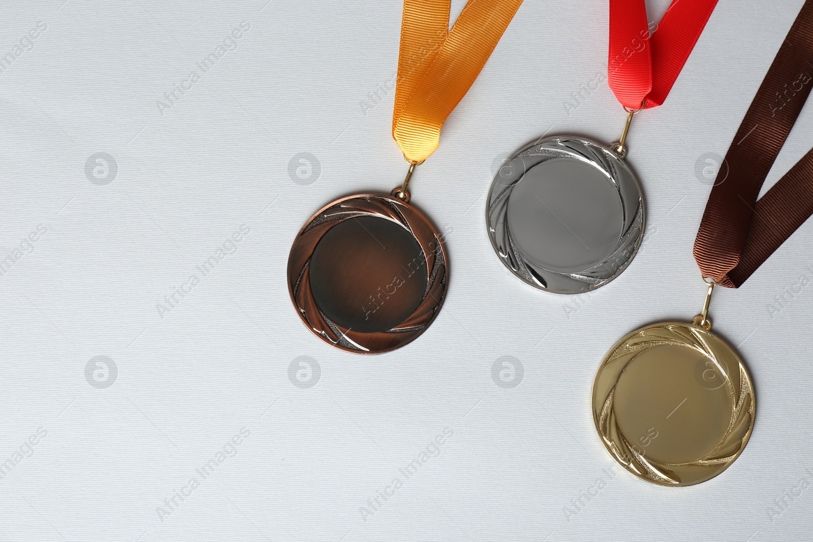 Photo of Gold, silver and bronze medals on white background, flat lay. Space for design