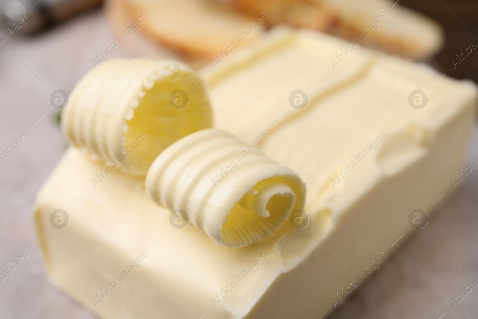 Photo of Tasty butter and curls on table, closeup