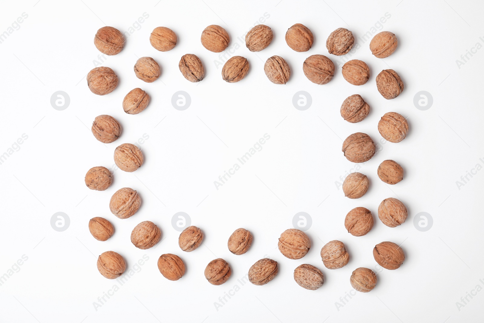Photo of Frame made with walnuts and space for text on white background, top view