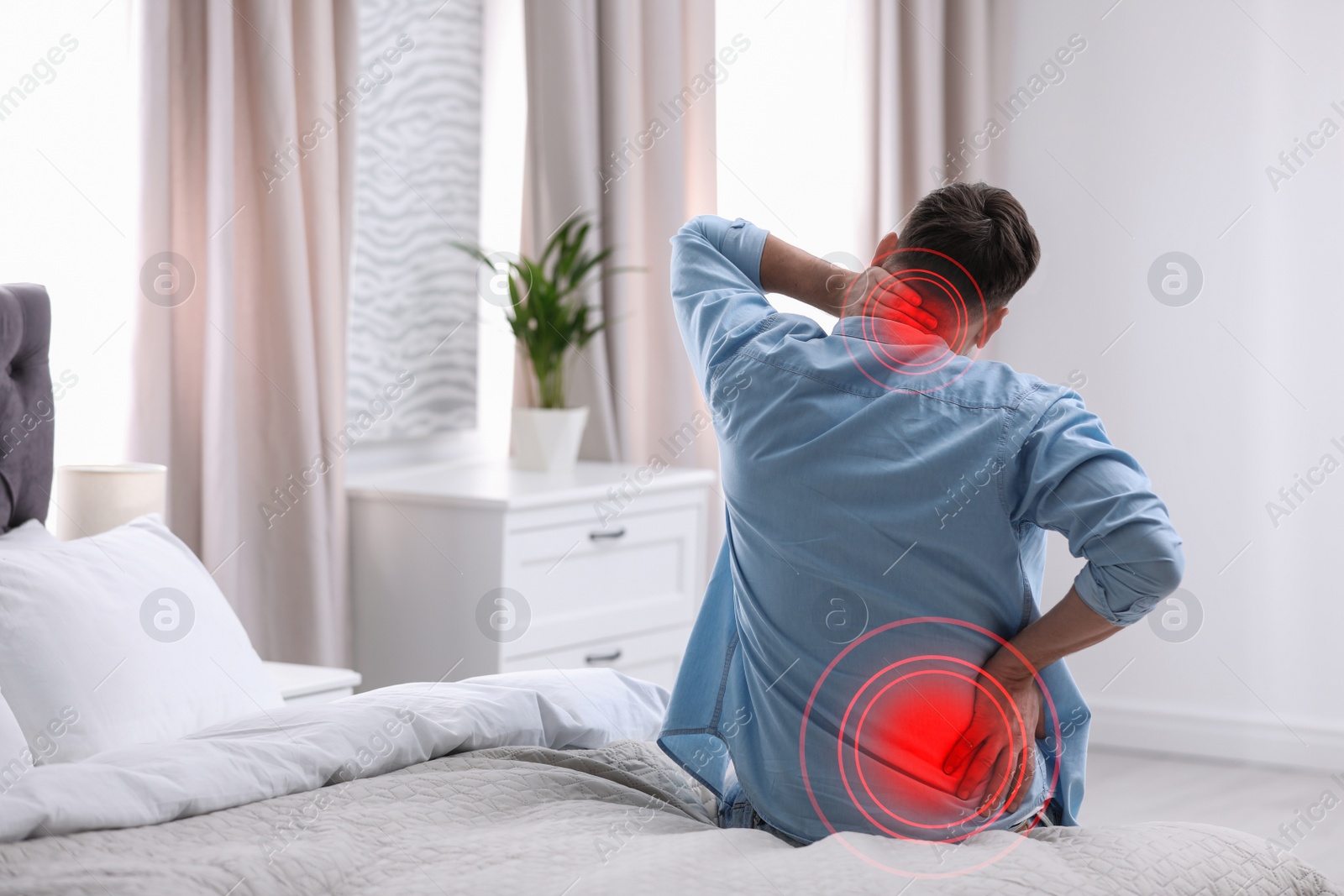 Image of Man suffering from back pain after sleeping on uncomfortable mattress at home