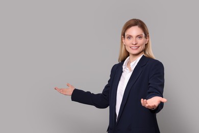 Photo of Happy real estate agent on grey background. Space for text