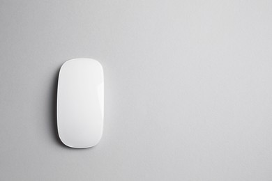 One wireless mouse on grey background, top view. Space for text