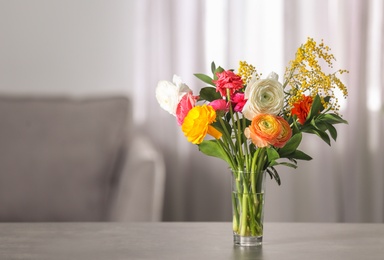 Photo of Vase with beautiful ranunculus flowers indoors