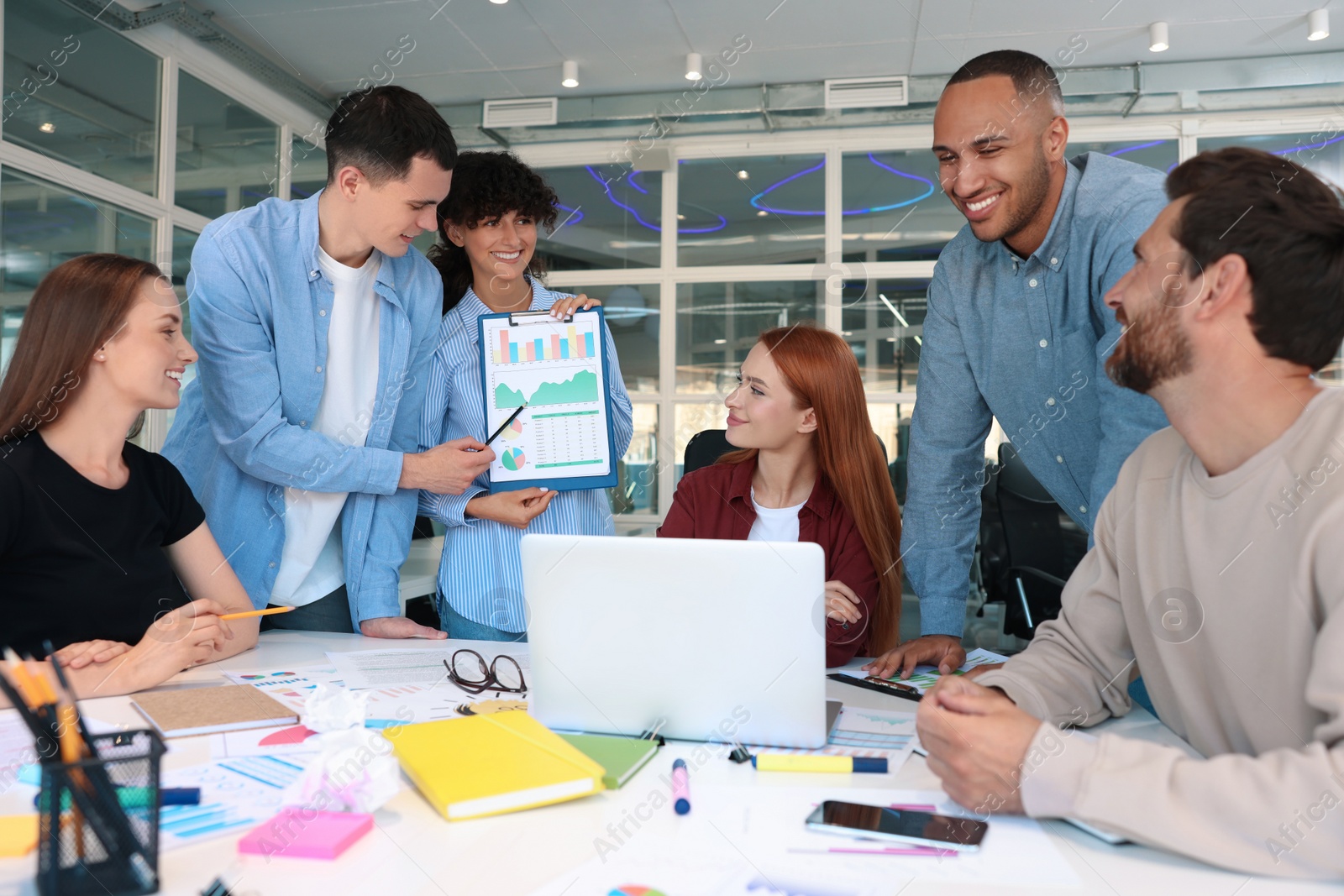 Photo of Team of employees working together at table in office. Startup project