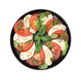 Photo of Plate of delicious Caprese salad with pesto sauce isolated on white, top view