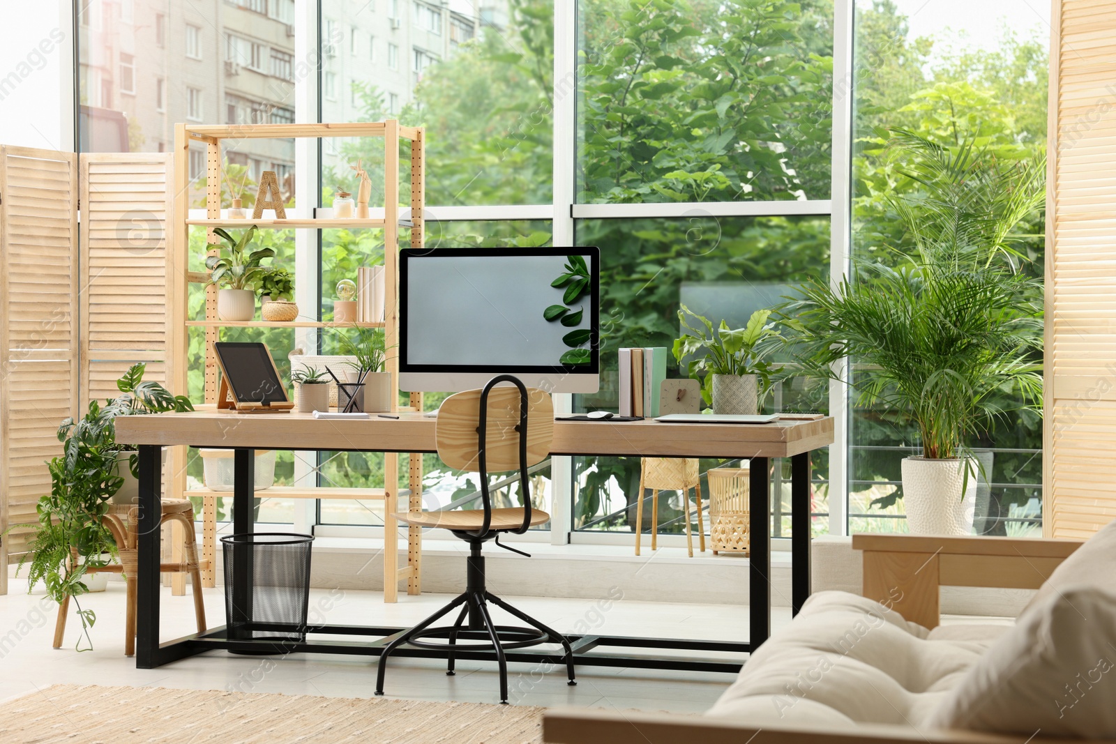 Photo of Comfortable workplace with computer in light room. Interior design