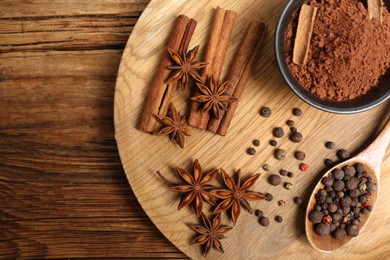 Photo of Aromatic anise stars and spices on wooden table, flat lay